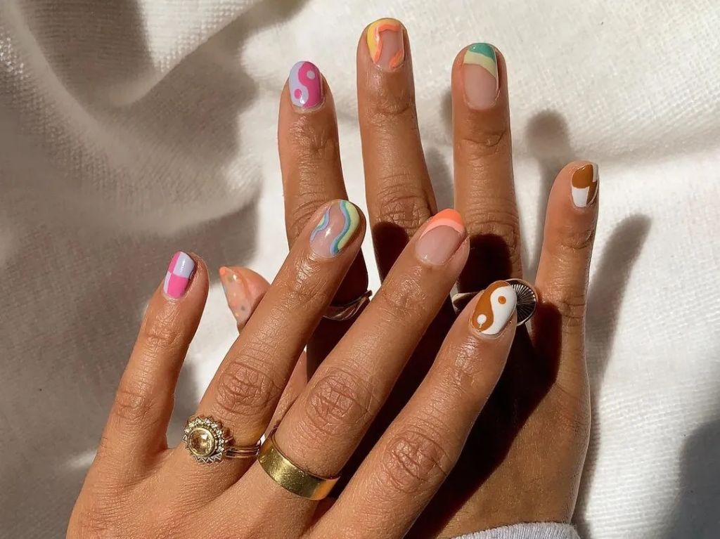 a hand with different nail shapes painted on the nails