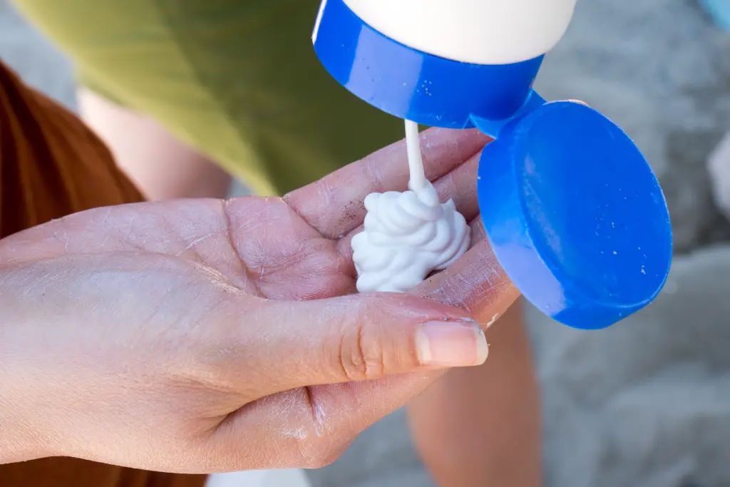 person applying sunscreen to hands