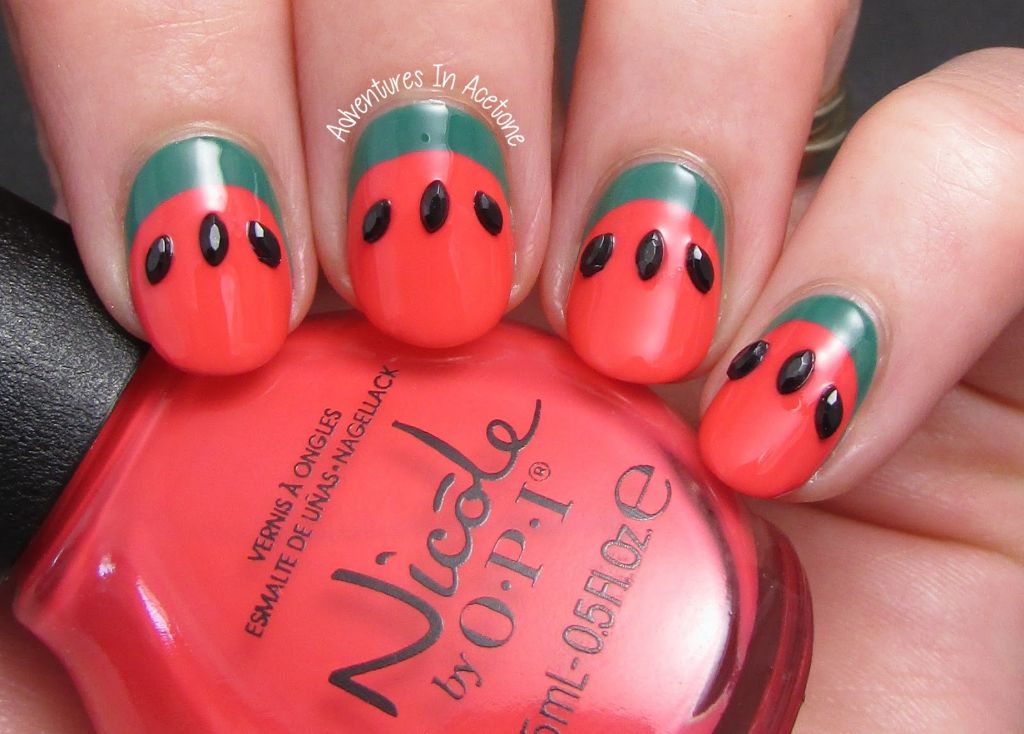 watermelon-inspired nail art with red, pink, green, and black polish.